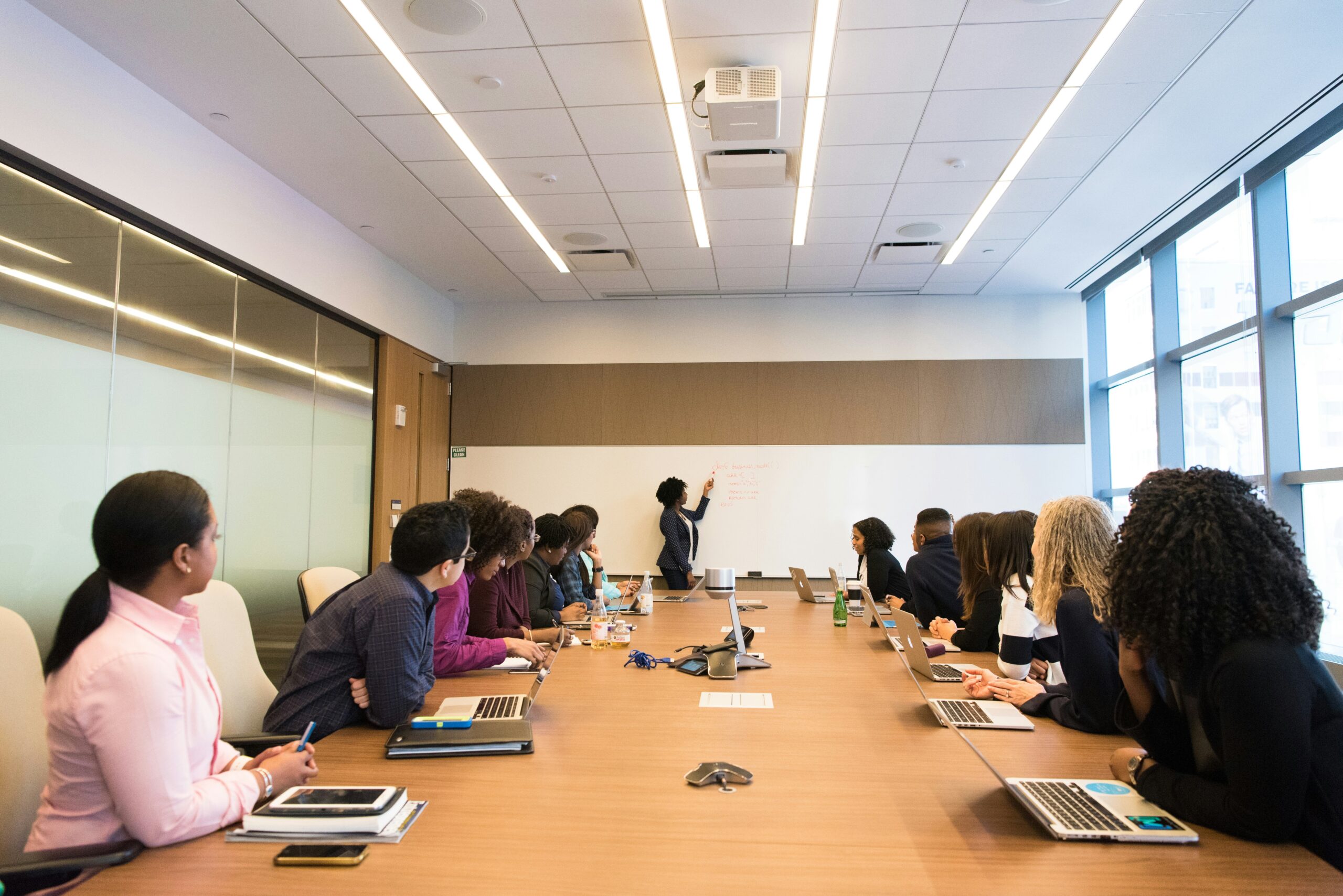 Sala riunioni aziendale con partecipanti seduti, time management aziendale tradizionale.
